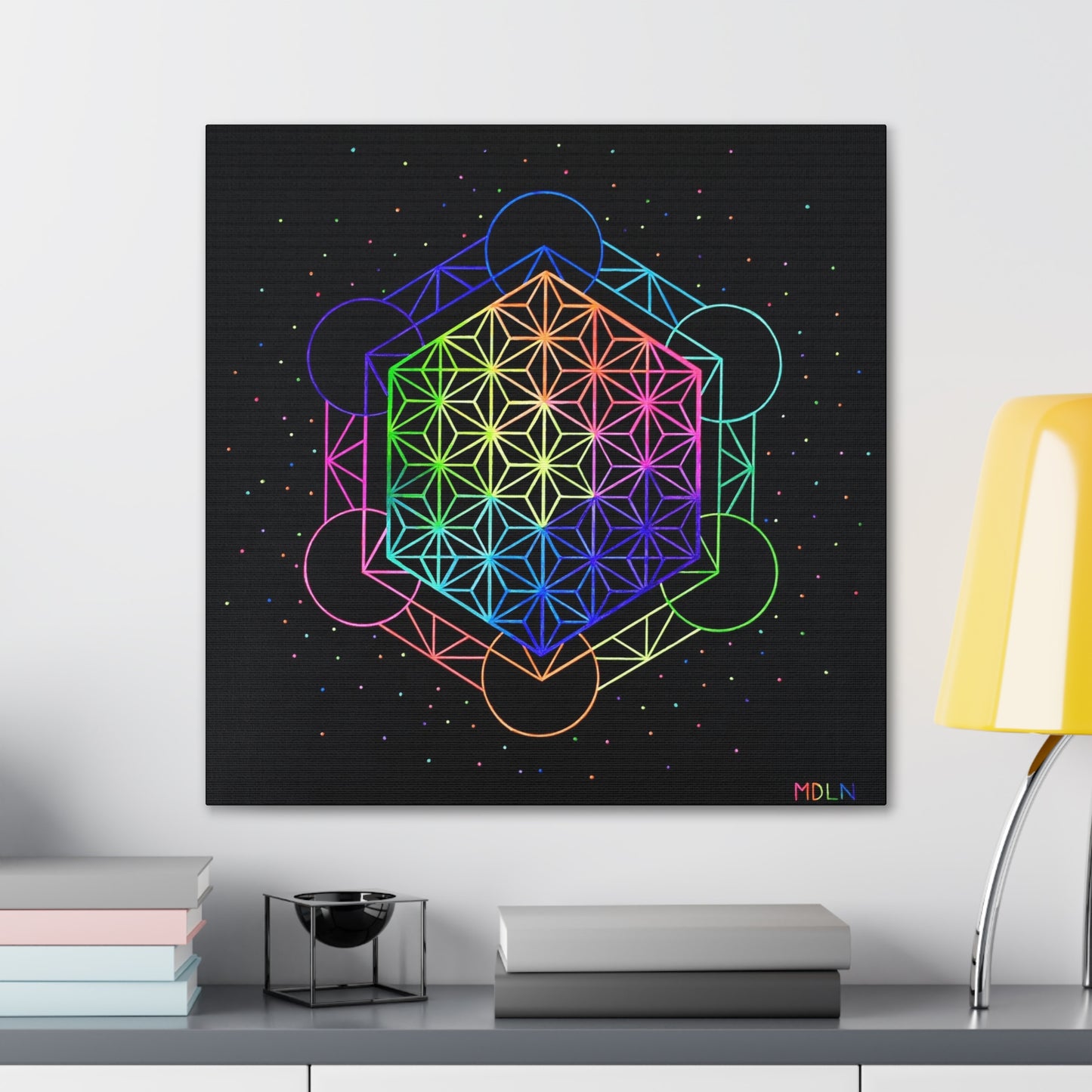 A bright neon sacred geometry art print on canvas, flower of life sacred geometry, hanging on a wall over a desk with objects on it