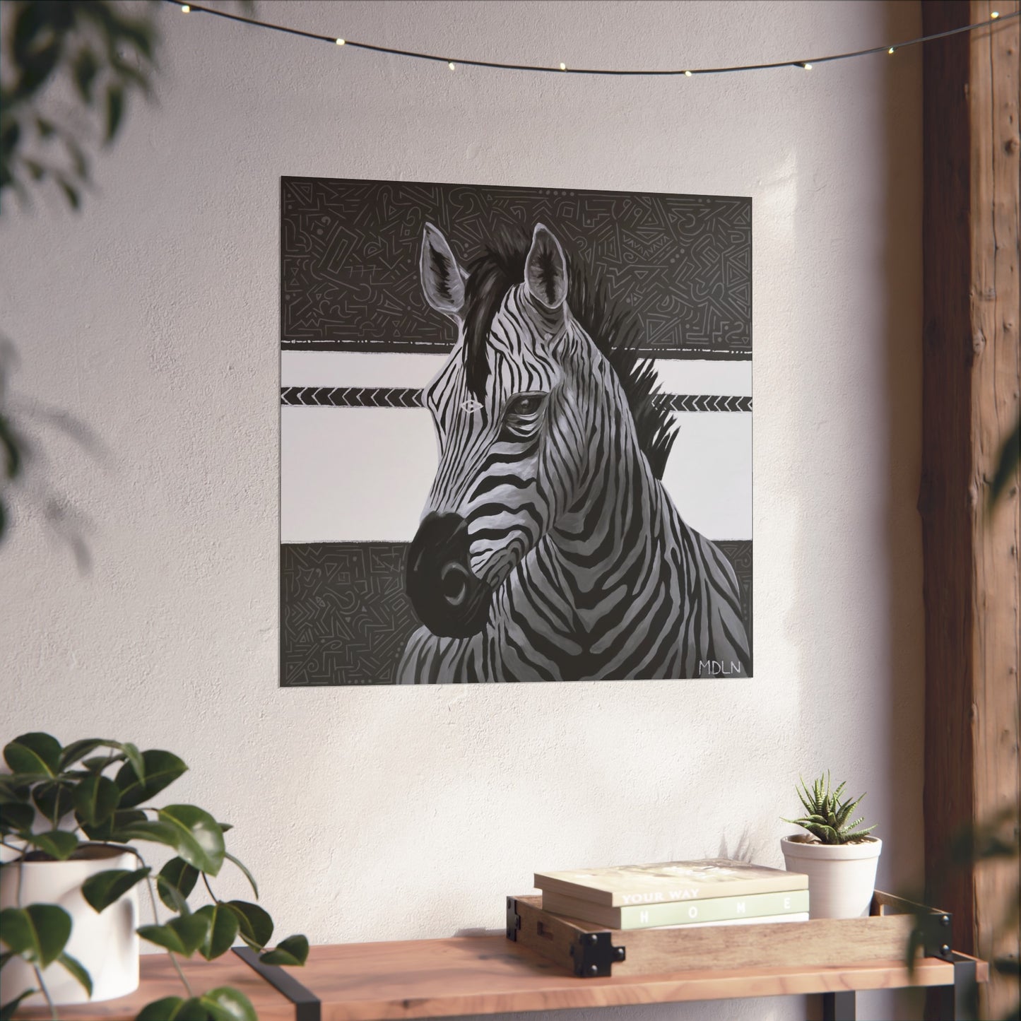 A black and white giclee art print of a majestic zebra painting with abstract background, zebra art hanging on a wall over a wooden table next to a plant
