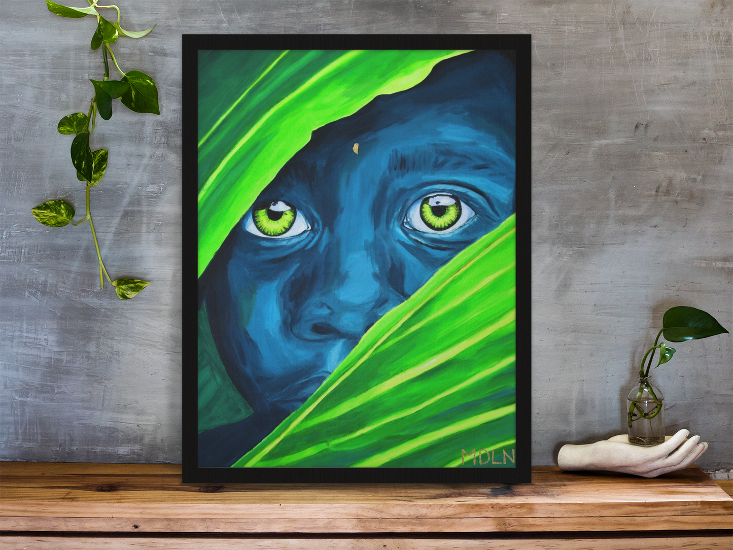 An original acrylic painting of an a young African Child with bright eyes peaking out from beyond some palm leaves, sitting on a table 