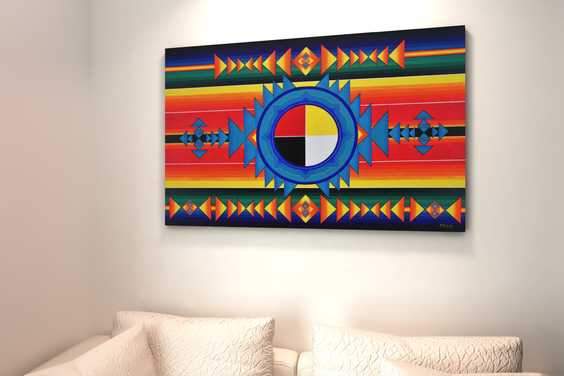 A beautiful Indigenous Medicine Wheel art print on canvas, hanging over a white couch