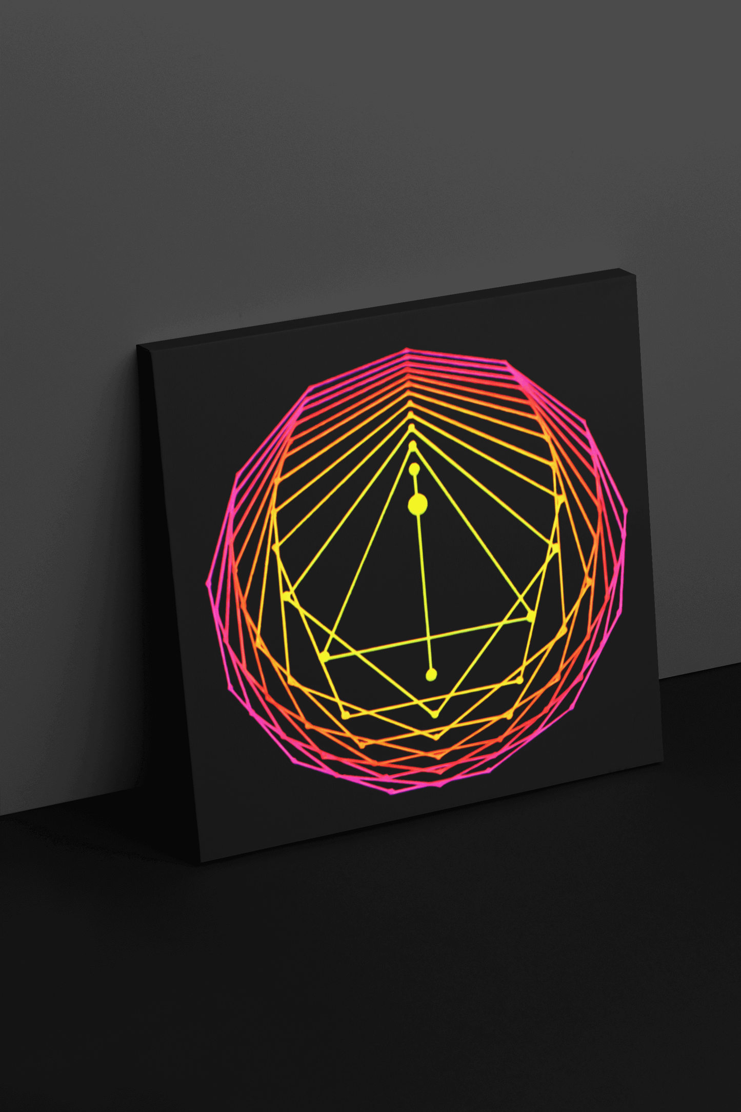 Giclee art print of an original acrylic painting of sacred geometry art in pink/orange/yellow tones, leaning up against a wall