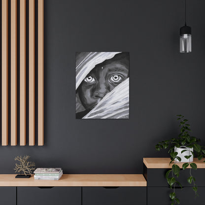 A small black and white art print of an African boy hanging on the wall in an office