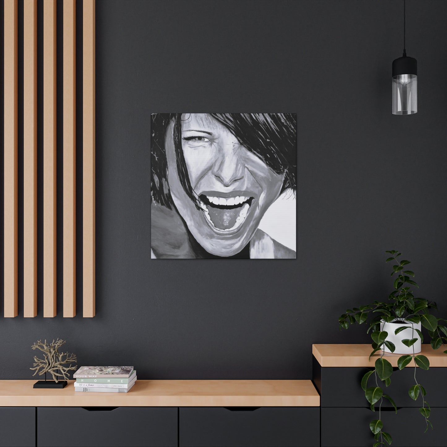 A small Black and White art print on canvas of a passionate woman showing emotion, hanging on a wall over a desk
