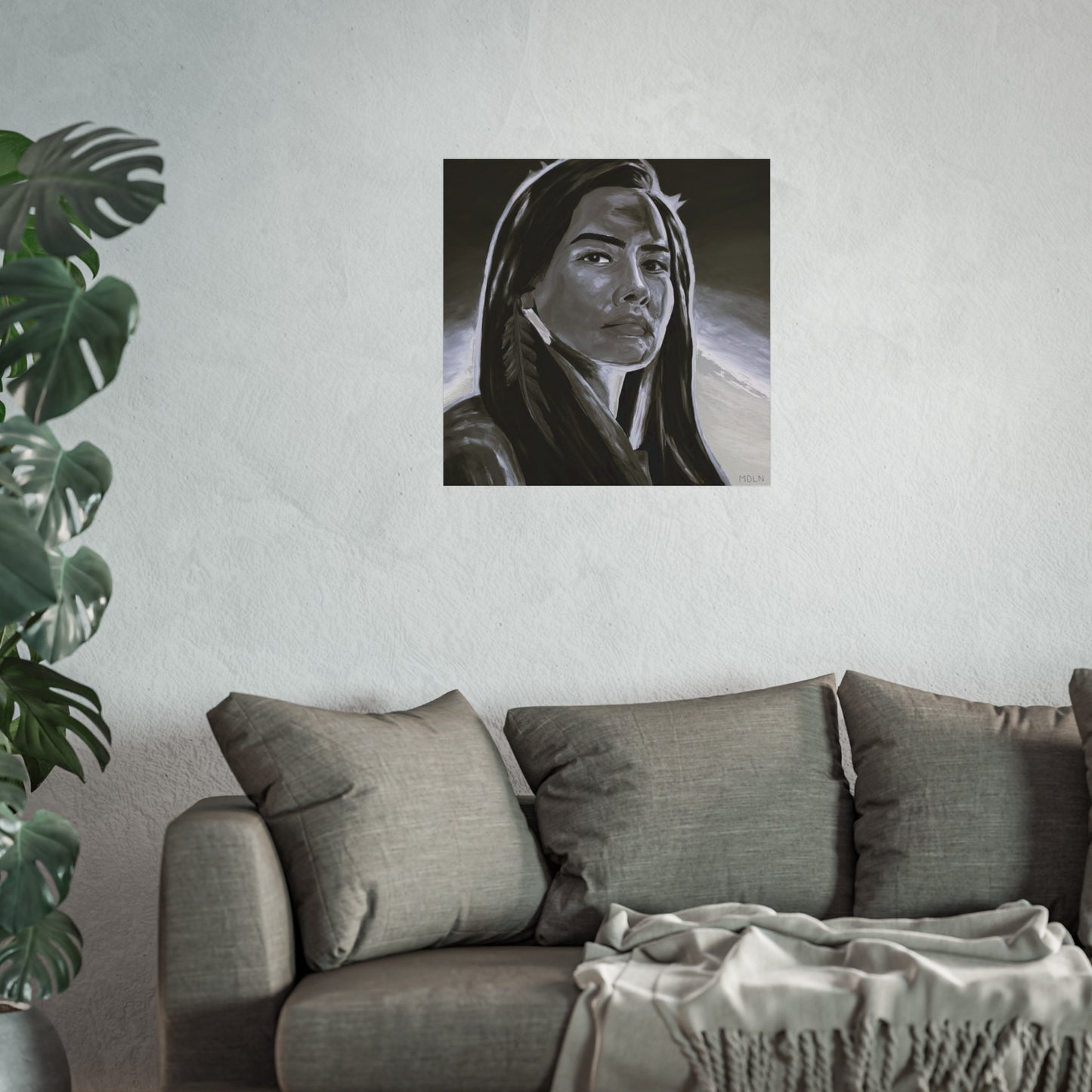 Black and white Indigenous giclee art print of an Aboriginal Woman with feather earring, hanging on the wall over a grey couch