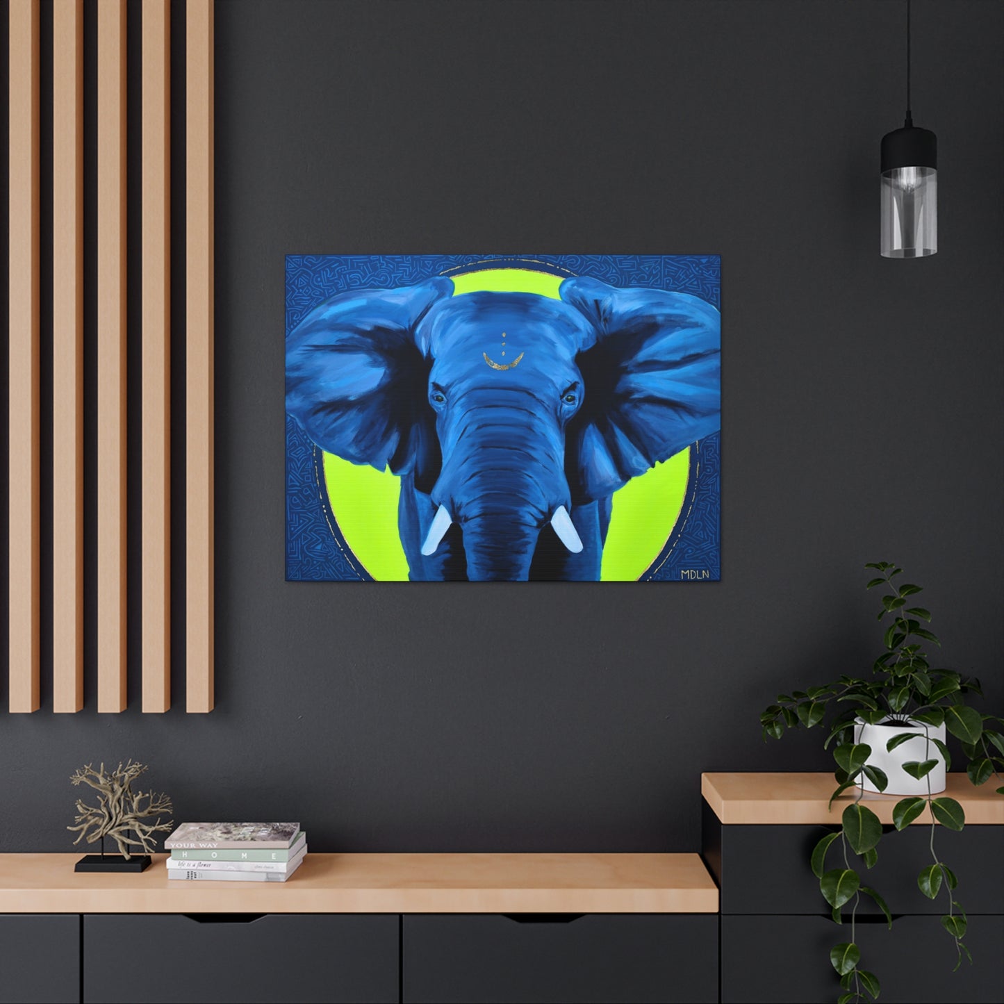 A small African Elephant art print in blue and yellow hanging on the wall in a black office