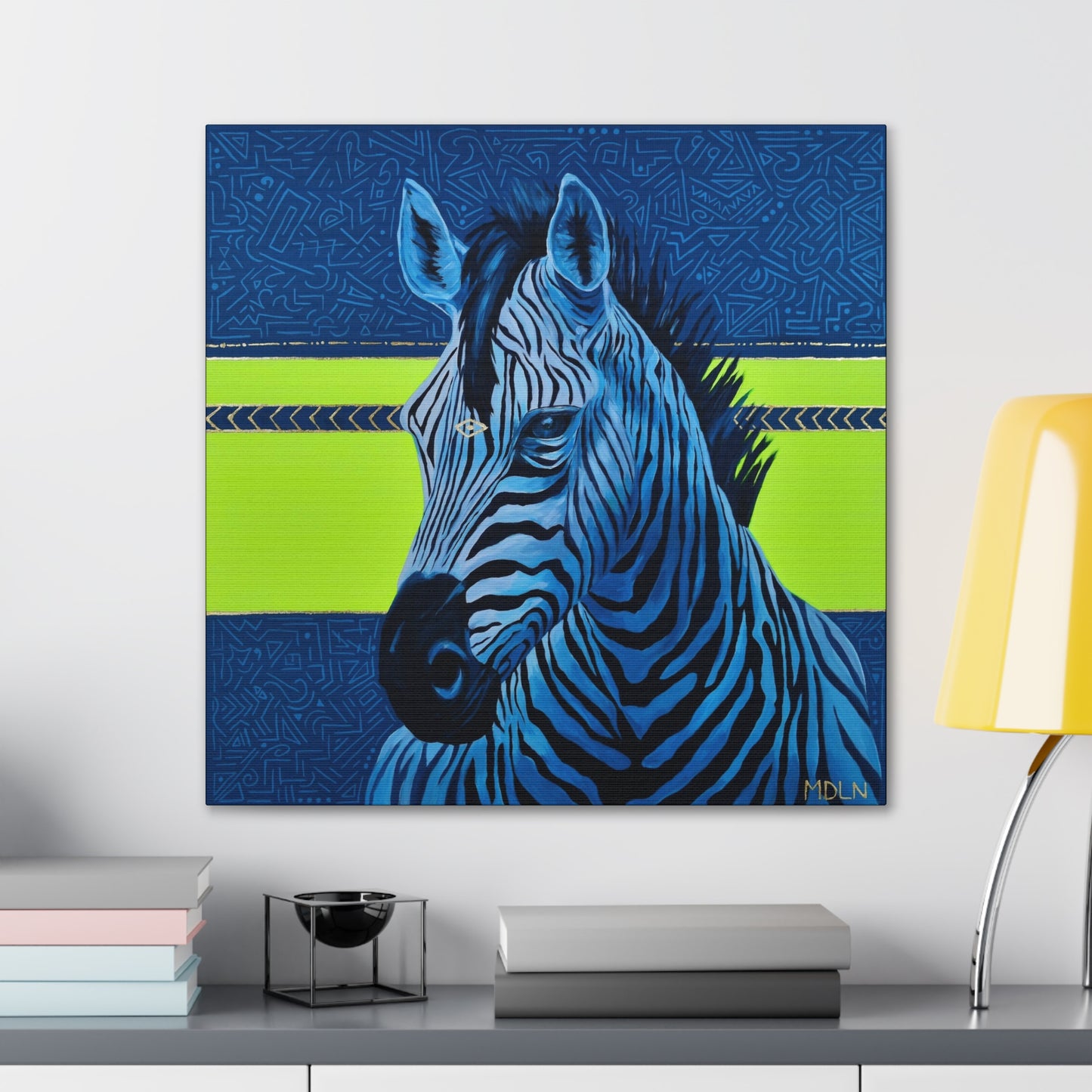 A bright and bold art print on canvas of a majestic zebra painting with blue and neon yellow abstract background, zebra art hanging on a wall over a desk with objects on it