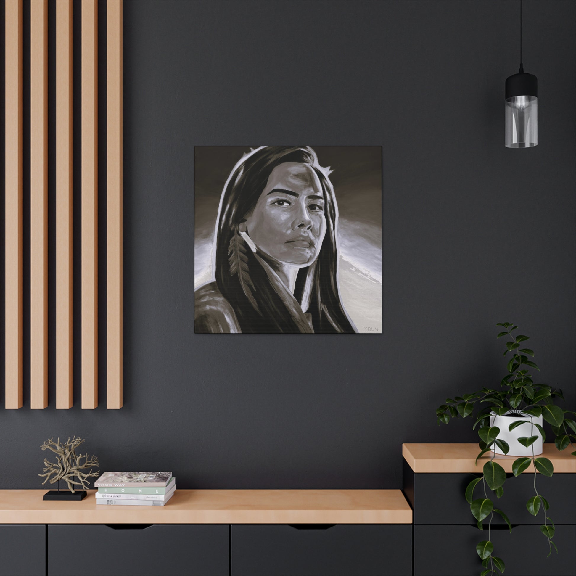 Black and white Indigenous art print on canvas of an Aboriginal Woman with a feather earring, hanging on the wall over a desk