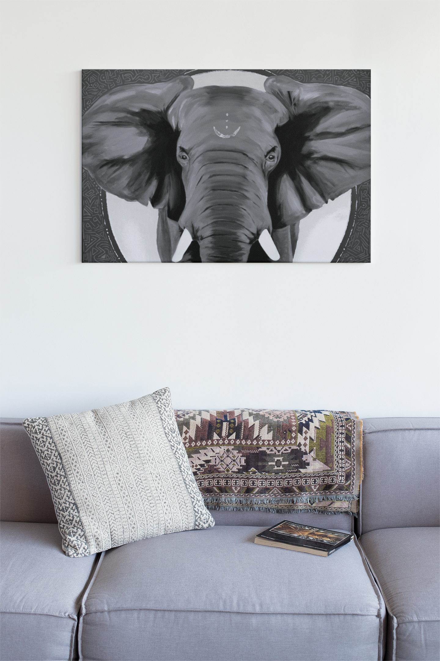 Black and white art of an African elephant art print hanging on the wall over a grey couch