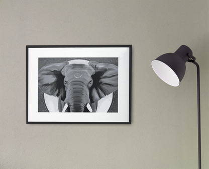 African elephant art print in black and white, framed, hanging on the wall next to a black lamp
