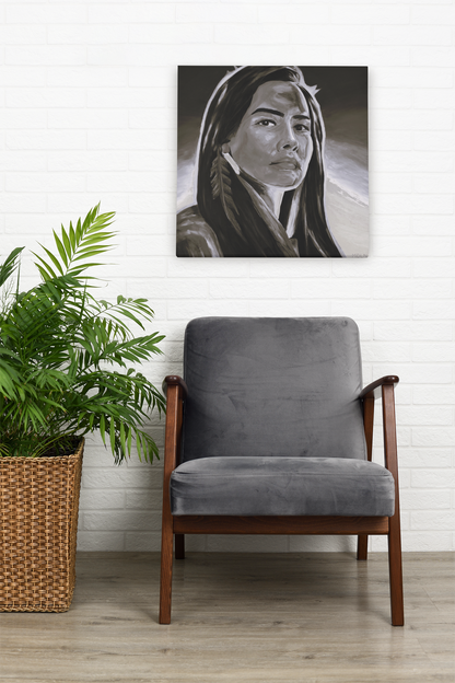 Black and white Indigenous art print on canvas of an Aboriginal Woman, hanging on the wall over a chair next to a plant