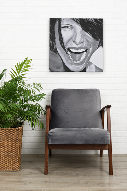 Black and White art print on canvas of a passionate woman showing emotion, hanging on a wall over a living room chair next to a plant