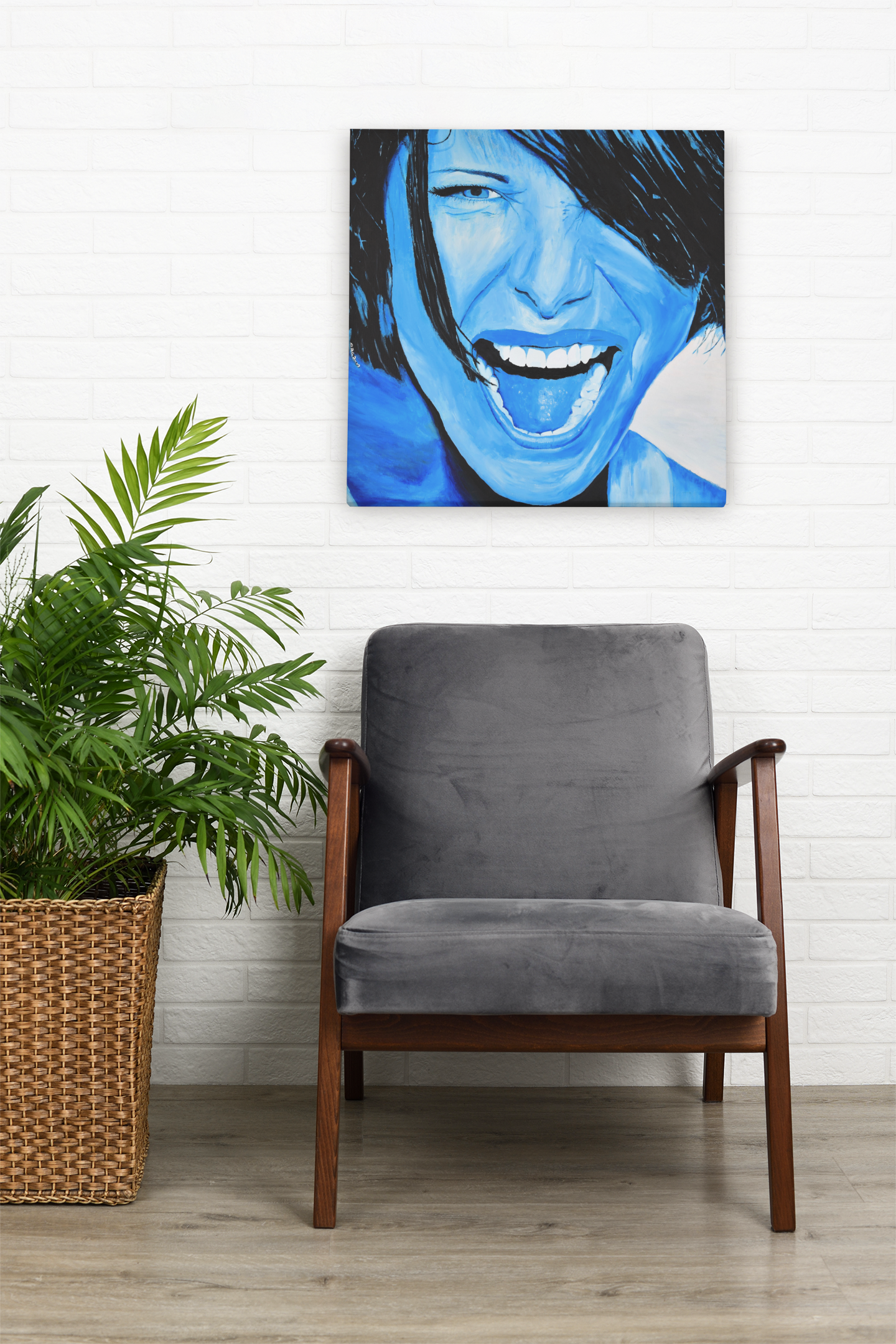 A bright blue giclee art print of a passionate woman showing emotions, woman portrait art, hanging on a wall over a living room chair next to a plant