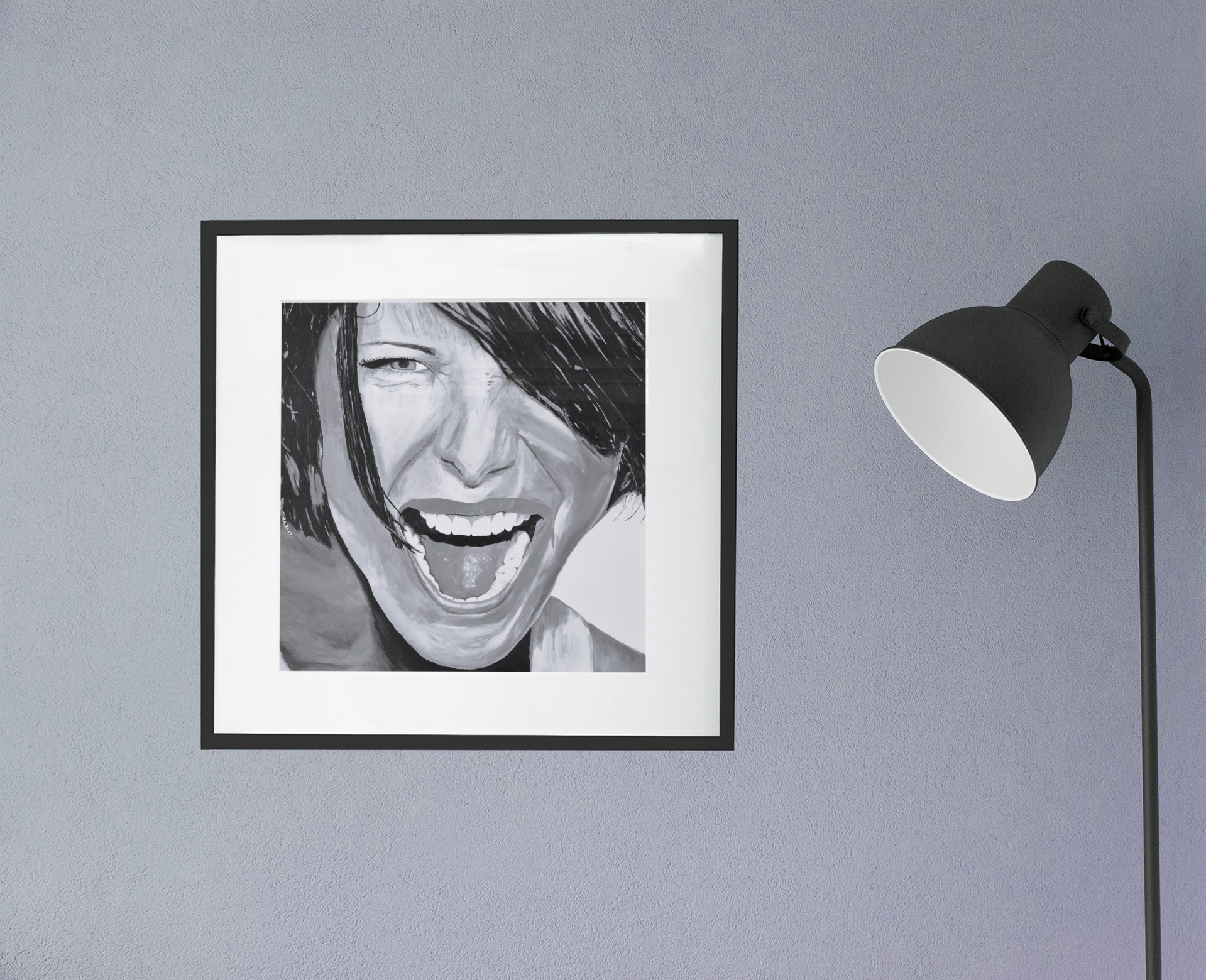 A beautiful black and white giclee art print of a passionate woman showing emotion, framed in black with white matting, hanging on a wall next to a lamp