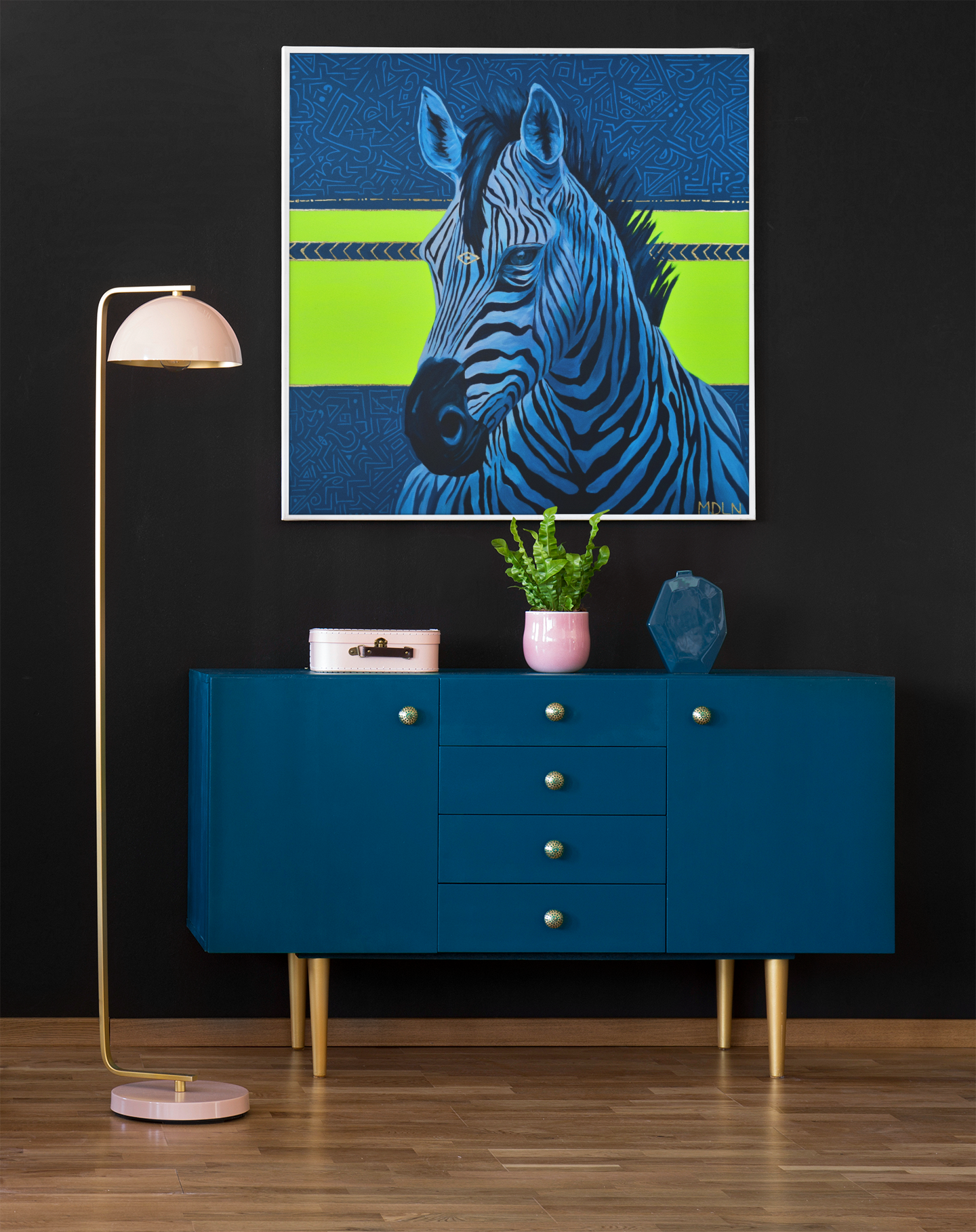 A bright and bold art print on canvas of a majestic zebra painting with blue and neon yellow abstract background, zebra art hanging on a wall over cabinets next to a lamp